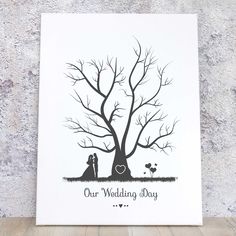 a card with the words our wedding day written on it and a couple under a tree