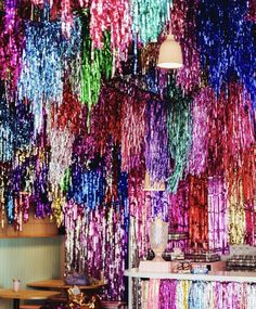 a room filled with lots of colorful streamers hanging from the ceiling next to a counter