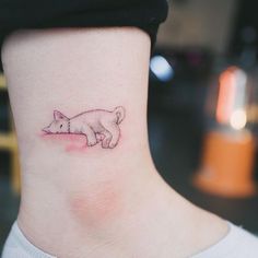 a small cat tattoo on the side of a woman's neck, with one paw in the air