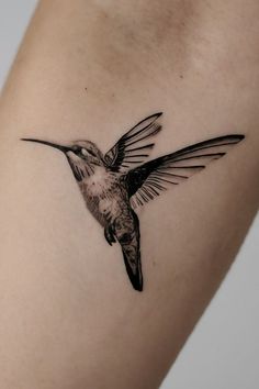 a small hummingbird tattoo on the arm