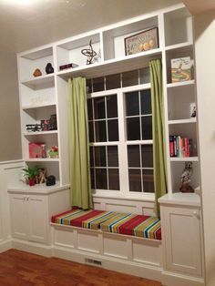 a living room filled with lots of furniture and bookshelves next to a window