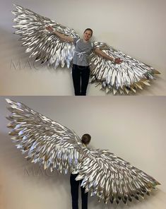 a man standing next to a wall covered in metal wings