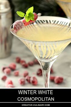 a close up of a martini in a glass with raspberries