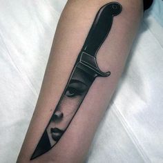 a woman's face and knife tattoo on the arm