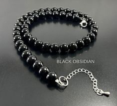 This Unique High Quality Black Obsidian (10mm, 8mm or 6mm)  Healing Crystal Beaded Necklace makes an Amazing gift they will ABSOLUTELY LOVE !  Crafted with High Quality Black Obsidian Crystal Beads , High Quality Beading Wire, Lobster Clasp & Adjustable Extender Please Note: The Necklace Length does not include the Extender (Extender is 1.5 inches) Perfect for Valentine's Day Gift , Birthday Gift , Anniversary Gift ,  Graduation Gift, Christmas Gift, Mothers Day Gift  , Fathers DayGift  , Gift f Obsidian Necklace And Earring, Envelope Necklace, Black Obsidian Crystal, Black Obsidian Bracelet, Obsidian Jewelry, Crystal Beaded Necklace, Handmade Crystal Necklace, Pyrite Bracelet, Energy Protection