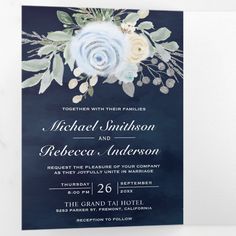 an elegant blue and white wedding card with flowers on the front, in watercolor