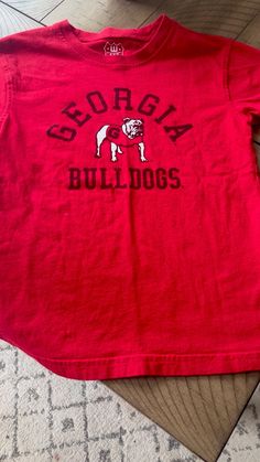 a red shirt that says georgia bulldogs on it