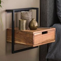 a wooden shelf with two vases on it next to a window sill in a bedroom