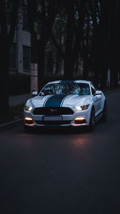 a white car parked on the street at night