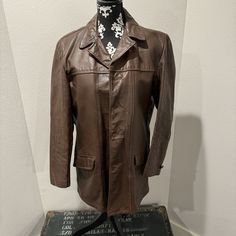 Embrace the allure of well-worn character with this Men's Jilliard Leather Button Jacket - Size Men's 38. Despite its signs of wear, this jacket exudes a classic style and fit that tell the story of countless adventures. The unique patina and distressed features make it a one-of-a-kind piece with unmatched character. Condition: This jacket has been well-loved and shows signs of wear, adding to its distinctive character. The pockets have holes on the inside, and the backside seam is worn out, contributing to the vintage appeal. Vintage Notch Lapel Sport Coat For Fall, Vintage Sport Coat With Button Closure For Business, Vintage Sport Coat With Pockets For Business, Retro Single Breasted Leather Jacket With Long Sleeves, Vintage Leather Jacket For Business In Winter, Vintage Sport Coat For Business In Fall, Vintage Outerwear With Snap Buttons For Fall, Vintage Fall Outerwear With Snap Buttons, Vintage Leather Jacket For Work