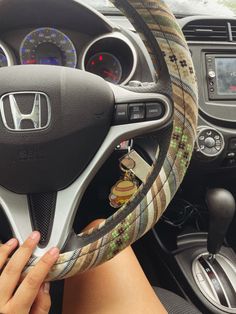 a person is holding the steering wheel cover in their car, while they are driving