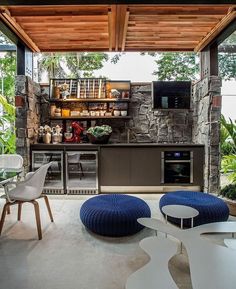 an outdoor kitchen with stone walls and flooring