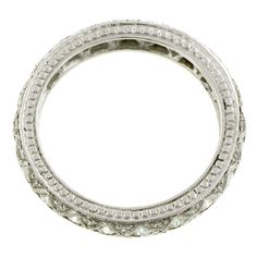 a white gold ring with round cut diamonds on the inside and outside, set against a white background