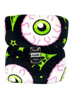 an eye pillow with green and pink designs on the front, sitting on top of a white background