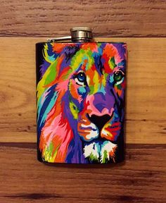 a flask with a colorful lion on it sitting on top of a wooden table