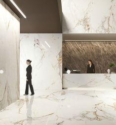 two people standing in front of a marble reception desk