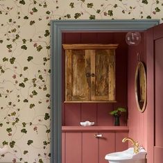 a bathroom with pink walls and floral wallpaper