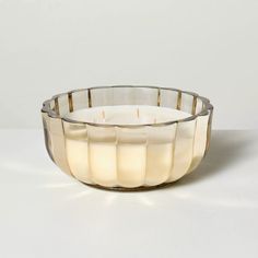 a white candle sitting inside of a glass bowl