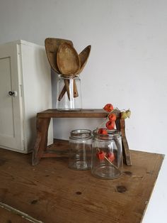 some glass jars and wooden spoons on a table