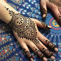 two hands with henna tattoos on them