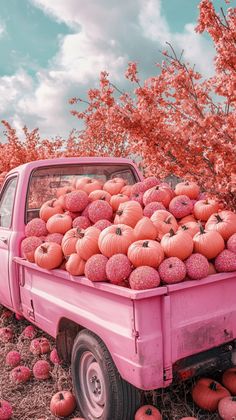 a pink truck filled with lots of pumpkins