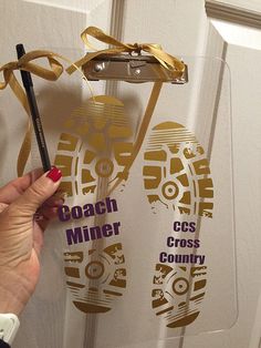 a person holding a pencil in front of a door with the words coach miner and cross country on it