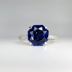 a blue and white diamond ring with diamonds around it