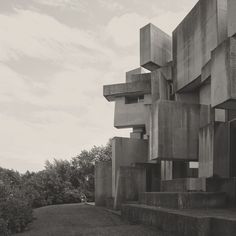 a black and white photo of a building made out of concrete blocks with trees in the background