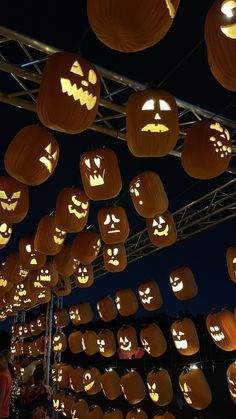 many pumpkins are lit up in the night sky with faces carved into them and eyes drawn on them