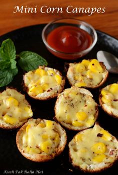 mini corn canapes on a black plate