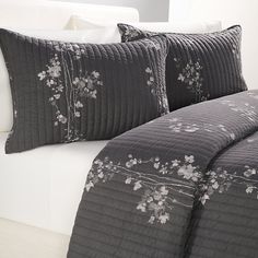 a bed with black and white comforters on it