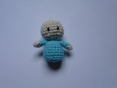 a small crocheted stuffed animal sitting on top of a white table next to a blue wall