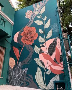 a mural on the side of a building with flowers and leaves painted all over it