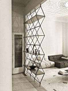 a black and white photo of a living room with a book shelf in the corner