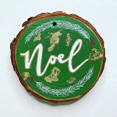 a wooden slice with the word noel painted on it