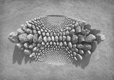 a black and white photo of rocks arranged in the shape of a sunburst