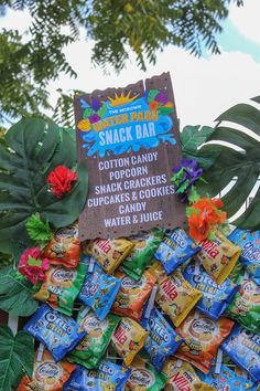 a pile of snacks sitting on top of a table next to some leaves and flowers