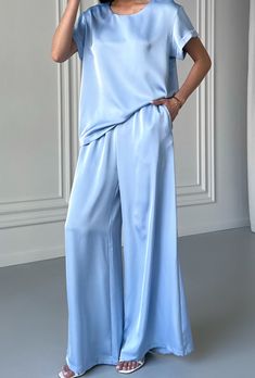 Light blue 2 piece satin loose fit set stylish and elegant!  The suit consists of a crew neck top with short sleeves and palazzo trousers with convenient pockets.  The suit will be an excellent choice for various occasions for an elegant casual look for every day, walks, as well as for special occasions for wedding guests, parties, family celebrations, receptions and more.    DETAILS - light blue  - satin  - loose fit - crew neck - short sleeve - wide leg   SIZES   This suit is available in 4 si Elegant Blue Wide Leg Sets, Elegant Short Sleeve Satin Set, Blue Satin Sets For Summer, Formal Satin Sets For Summer, Pantsuit Wedding Guest, Satin Pantsuit, Wedding Guest Suit, Pantsuit Wedding, Wedding Guest Suits