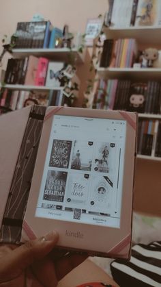 someone is holding up a kindle book in front of a bookshelf full of books