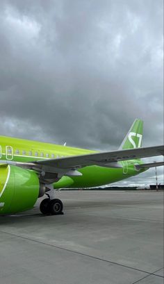 an airplane is painted bright green on the tarmac