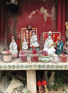 there are many statues on the table with candles in front of them and other decorations