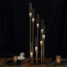 candles are lit on black plates and stand next to each other in front of a black backdrop