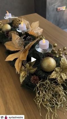 a table topped with candles and ornaments on top of a wooden table covered in greenery