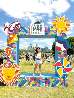 a woman standing in front of a colorful photo frame with a lion and giraffe on it