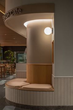 the inside of a restaurant with tables, chairs and round light fixture on the wall