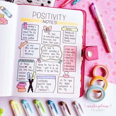 a notepad with writing on it next to two pens and a clipboard that says positivity notes