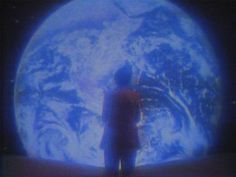 a man standing in front of a blue planet