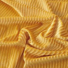 close up view of yellow fabric textured with fine lines and stripes, as seen from above