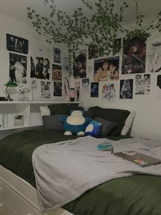 a bed room with a neatly made bed and lots of pictures on the wall above it