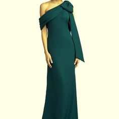 a woman in a long green dress posing for the camera with her hands on her hips